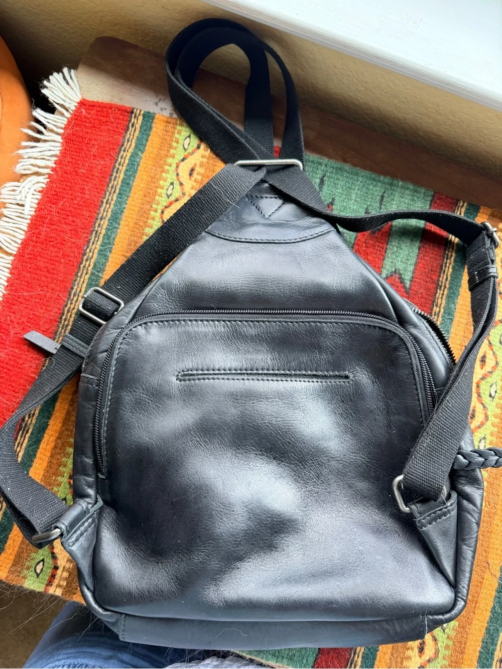 Black trianglular leather backpack with multiple pockets